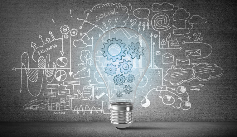 Drawing of light bulb in front of ideas board